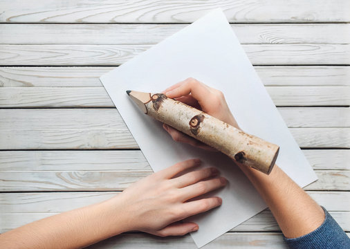 The hand holds a large pencil. Write or draw with a pencil. Writer concept. Right-hander.