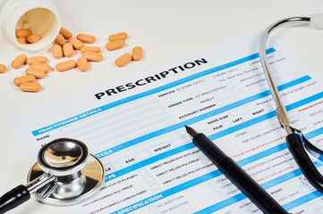prescription order form, pills on phonendoscope background and pen