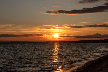Fototapeta premium yellow red sunset over the sea, horizon, beach, dark clouds