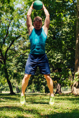 Fitness Trainer doing workout in nature with the kettle bell