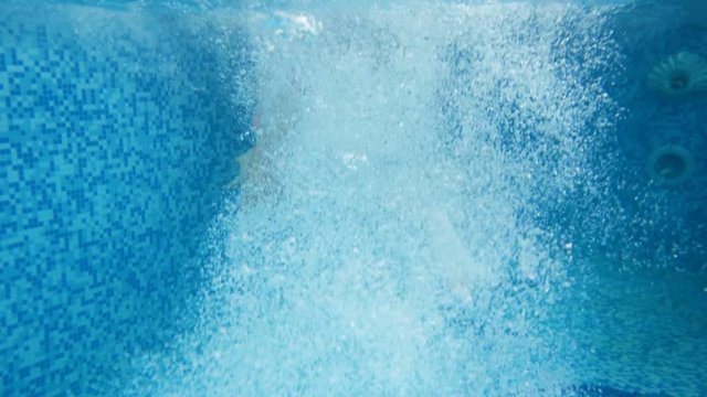 Underwater 4k footage of two teenage girls jumping and diving in swimming pool