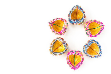 Happy Diwali - Clay Diya lamps lit during Dipavali, Hindu festival of lights celebration. Colorful traditional oil lamp diya on white background
