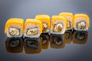 sushi Roll with melted cheese on black with reflection