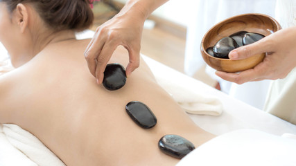 close up beautiful and healthy woman  during a back stone therapy massage in spa salon