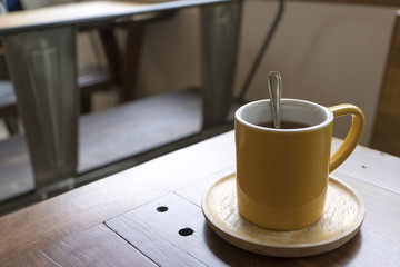 Yellow Coffee Mug Put on an old wooden table in a coffee shop.