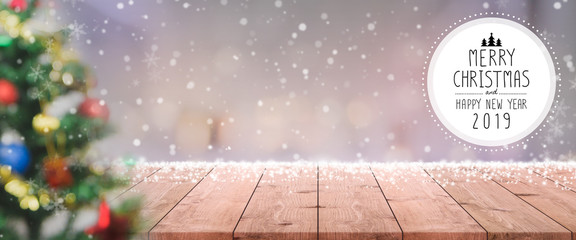 Christmas and Happy new year 2019 on empty wood table top on blur bokeh christmas tree with...