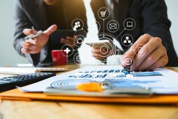 Working team meeting concept, businessman using smart phone and laptop and digital tablet computer with virtual interface icons network diagram office in morning light