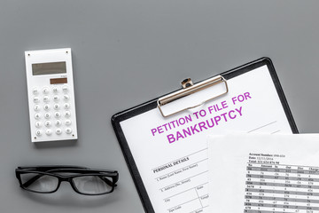 Petition to file for bankruptcy. Empty form ready to fill near calculator on grey background top view copy space