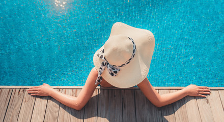 Portrait of asian woman relaxing in swimming pool with sunbathe