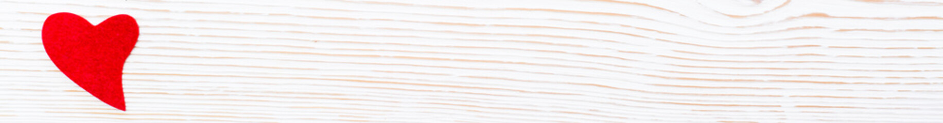 Red heart from felt on a white wooden background. Copy space. Web banner