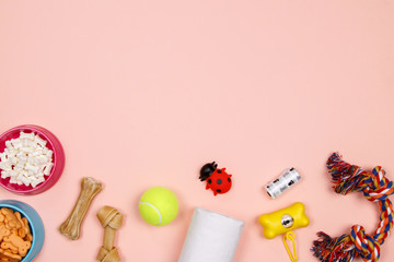 Dog accessories, food and toy on pink background. Flat lay. Top view.