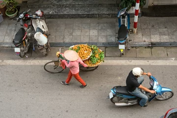 Zelfklevend Fotobehang Fruit vendor walking on street of Hanoi, Vietnam　ハノイの通りを歩く行商人（ベトナム） © wooooooojpn