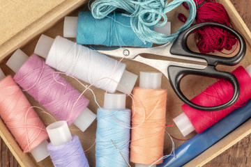 Fototapeta na wymiar Overhead closeup photo of sewing box with threads and scissors