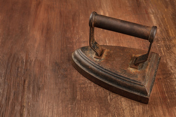 A photo of a vintage iron on a dark background with a place for text