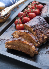 Grilled pork ribs with baked cherry tomatoes.