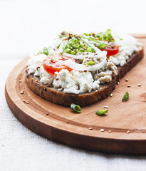 Smorrebrod. Traditional Danish open sandwich with cheese, forshmak, tomatoes, onions and sesame seeds.