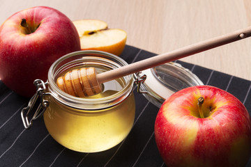 Jewish holiday Rosh Hashanah background with honey and apples on wooden table.