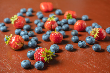 Strawberries and blueberries on a wooden table