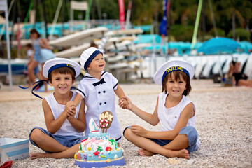 Sweet baby boy and his brothers, celebrating first birthday with sea theme cake and decoration