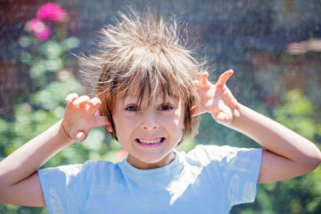 Cute little boy with static electricy hair, having his funny portrait taken
