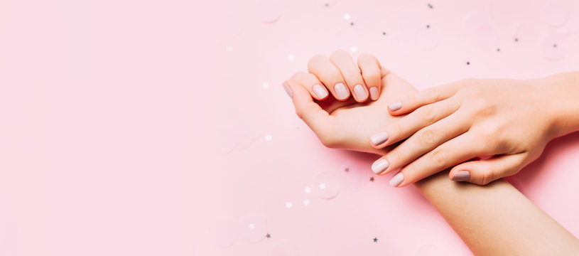 Beautiful woman manicure on creative pink background. Minimalist trend.