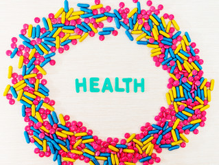The word letters Health and various medication and pills