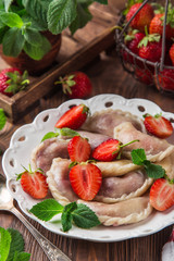 dumplings with strawberry (Vareniki, pierogi), rustic background