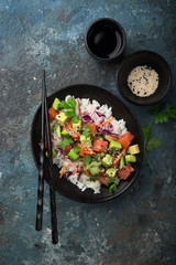 avocado and salmon poke bowl, dark background