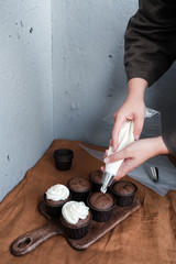  Women's hands decorate cupcakes