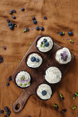 Obraz na płótnie Canvas Cupcakes with cream and fresh berries on the table