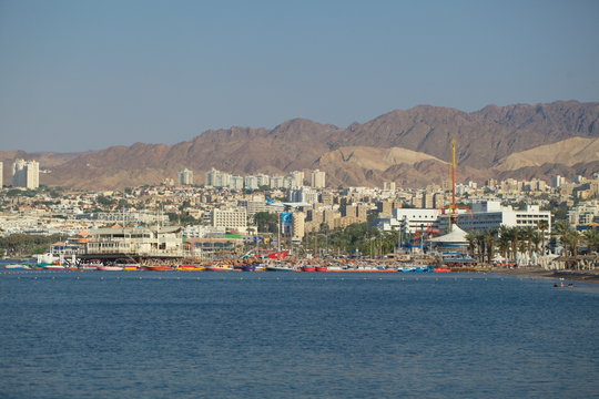 plane lands on the background of the city of Eilat Israel near the sea