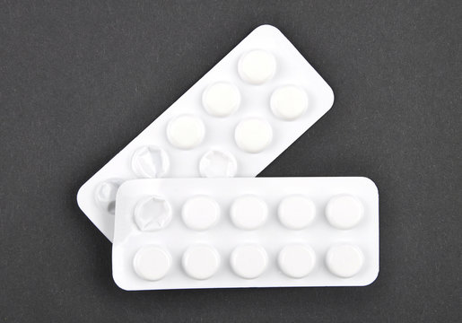 Tabletten in Verpackung auf schwarz