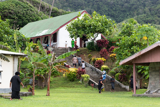Fijians walking up stairs to church in village