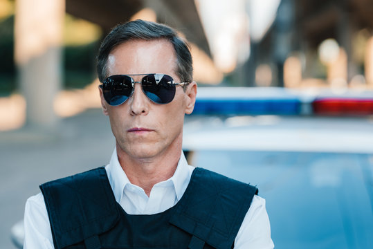 Close Up Portrait Of Mature Policeman In Sunglasses Looking At Camera