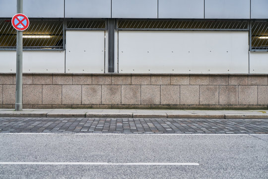 Stra&szlig;e und B&uuml;rgersteig vor Wand in Stadt