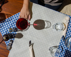 Tisch in Bergrestaurant mit Rotwein und blau kariertem Tischtuch