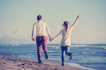 Loving young couple on a beach at autumn sunny day