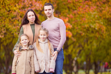 Portrait of happy family of four in autumn day