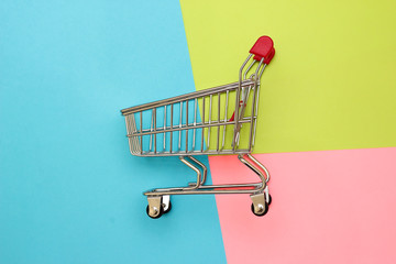 Self-service supermarket full shopping trolley cart on colorful background