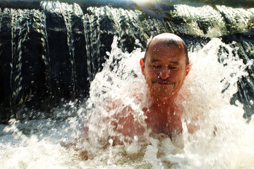 The elderly man in cold water. Hardening. Healthy lifestyle.  - obrazy, fototapety, plakaty