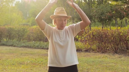 Funny elderly woman dances and laughs outdoors - Powered by Adobe