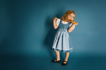 Little  girl in traditional german clothes dirndl eating bretzel - 222279797