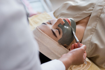 Young woman with facial mask mud