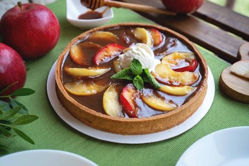 Apple tart with caramel on white plate