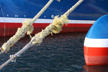Frayed ropes with fishing boats in background
