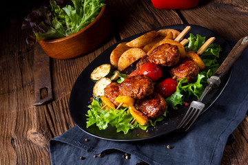 Meatballs skewers of tomato, paprika and baked potato quarters