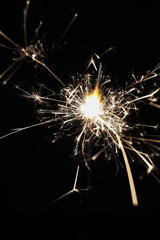 Gun powder sparks shot against dark background.