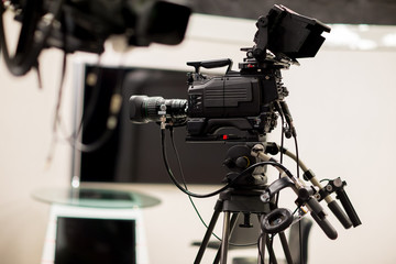 Camera in studio broadcasting news.