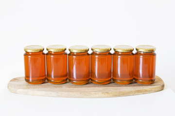 Jars of organic honey on white background