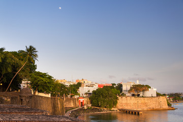 Outer wall of San Juan, Puerto Rico, with ancient mansion La Fortaleza on the right, at sunset